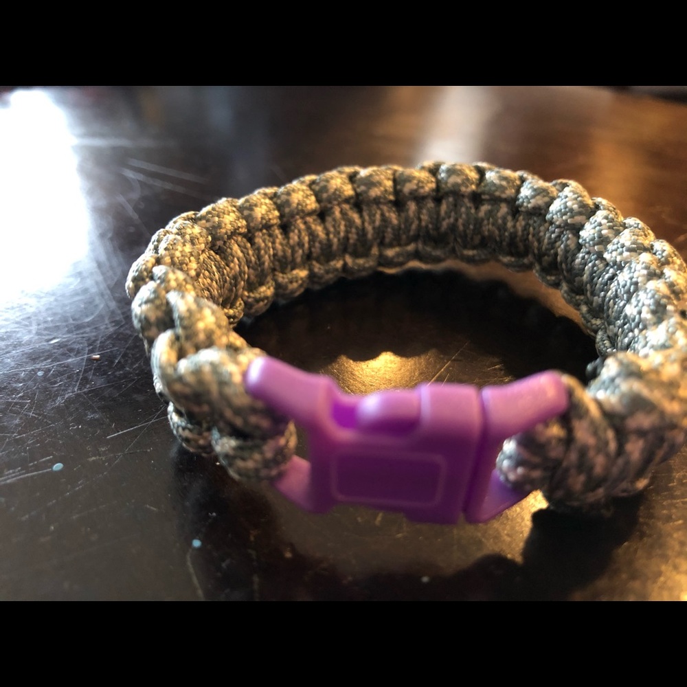 White and gray paracord bracelet w/ a purple clip